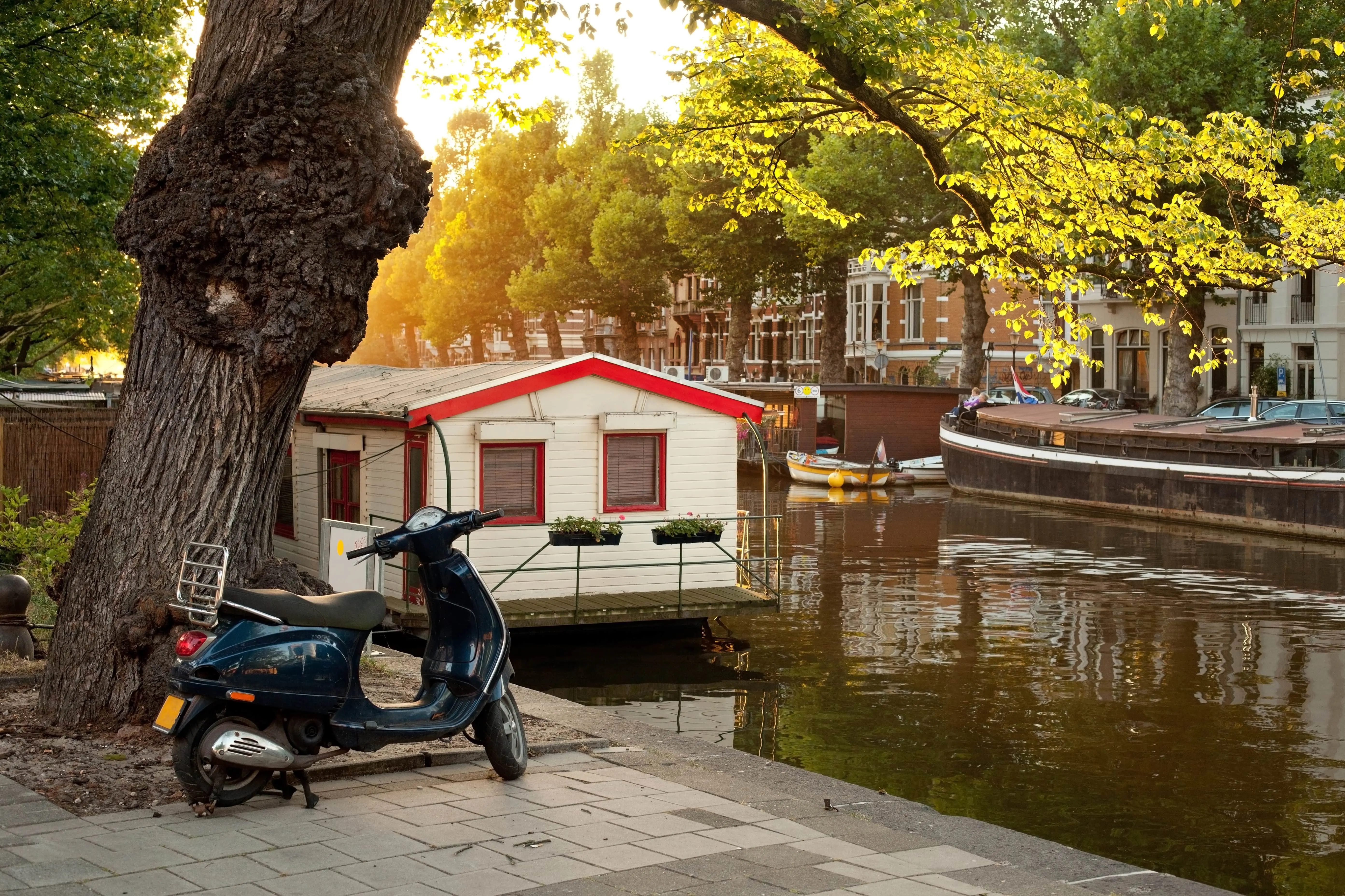 Tourist riding a scooter along Amsterdam canals