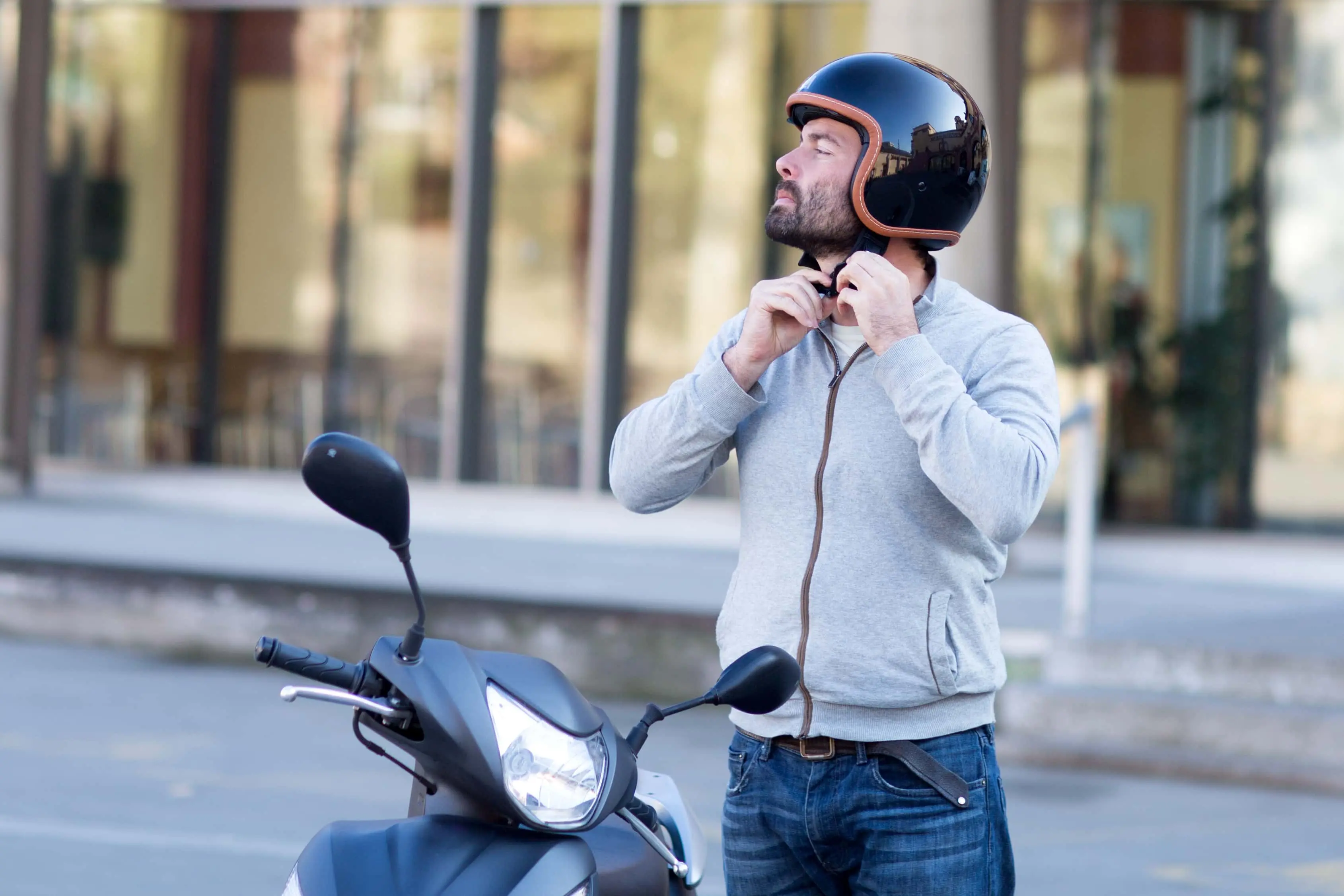 Scooter rider putting on a helmet before riding